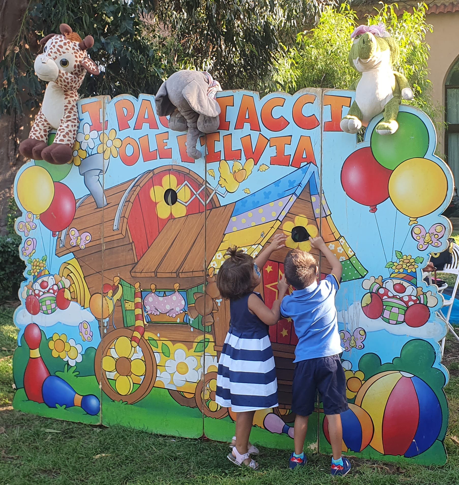 Due bambini giocano davanti al cartellone dei Pagliacci Ole e Ilvia