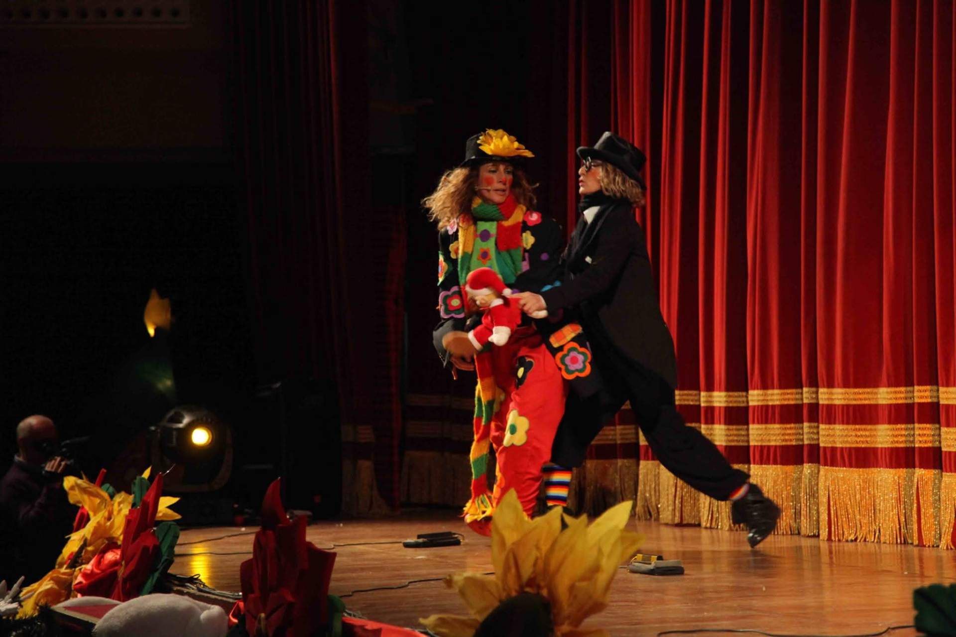 Due personaggi in scena tra le tende rosse del teatro