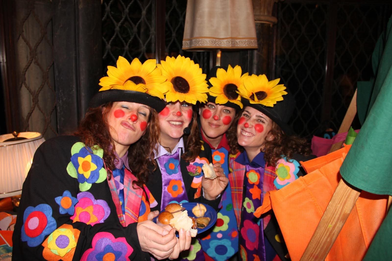Quattro pagliacce sorridenti con cappelli di girasole