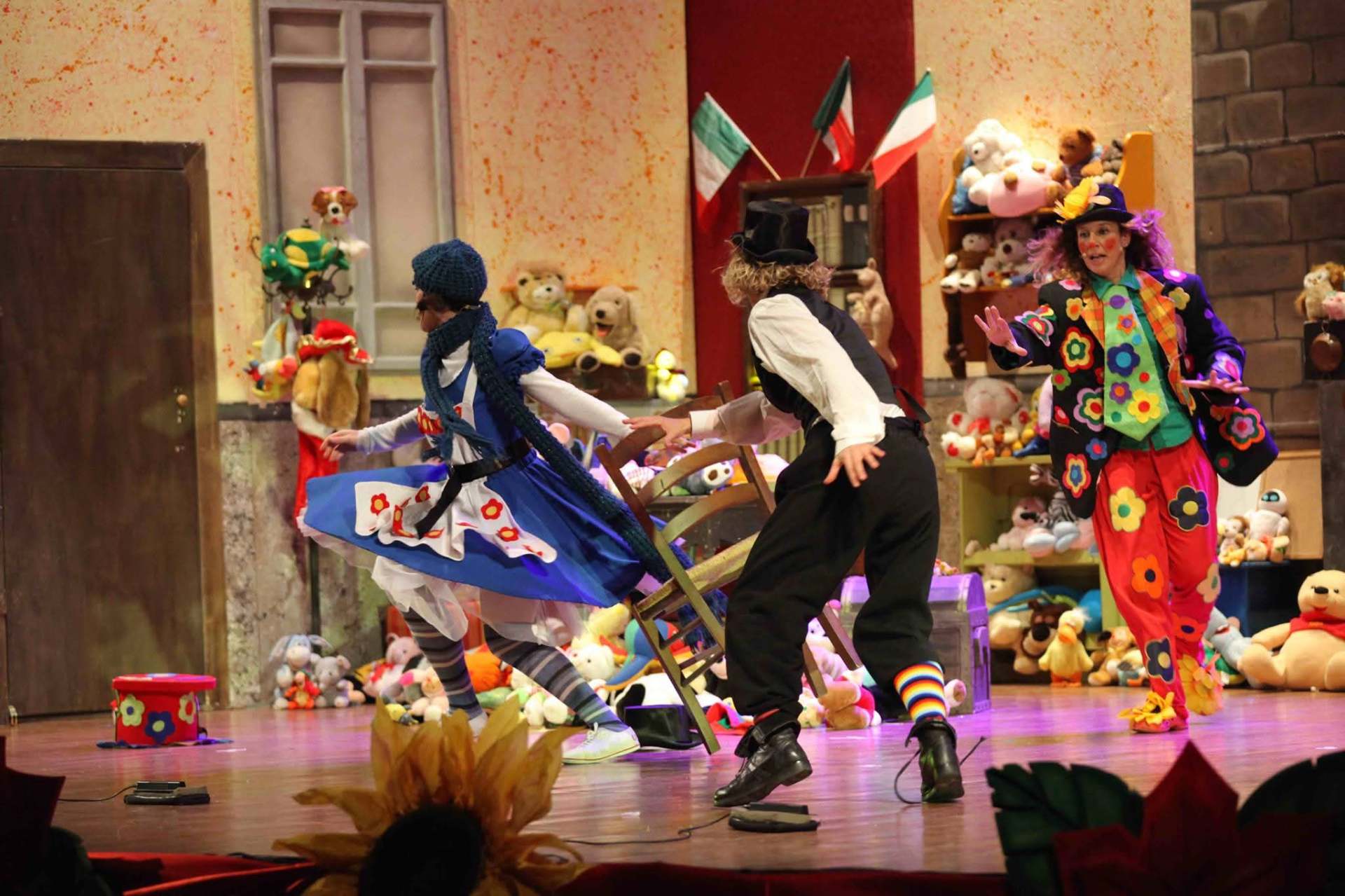 Scena teatrale con una pagliaccia e due personaggi in azione