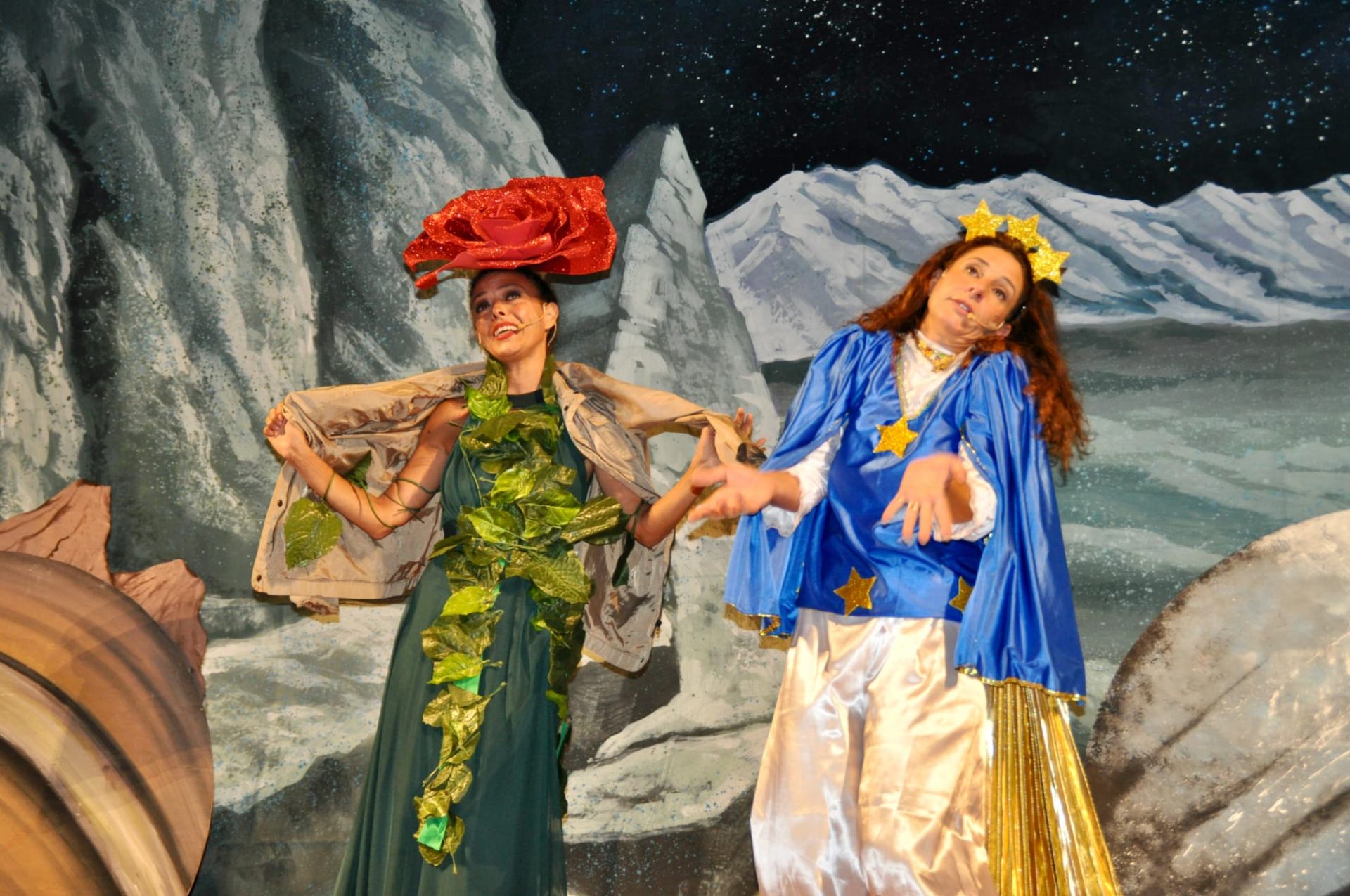 Due attrici in costume di rosa e stella in scena spaziale