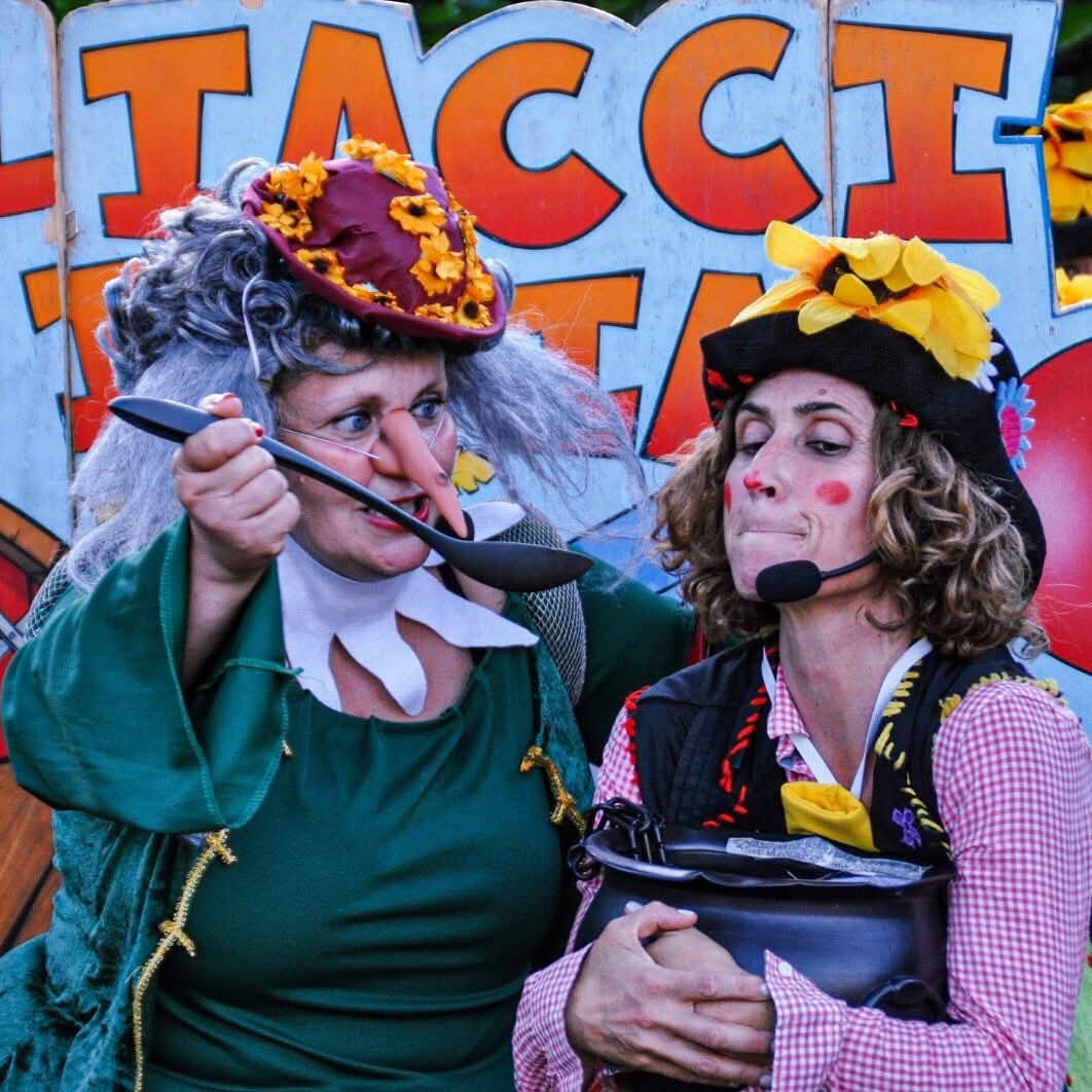 Due pagliacce in scena con cucchiaio e pentola durante una lettura animata