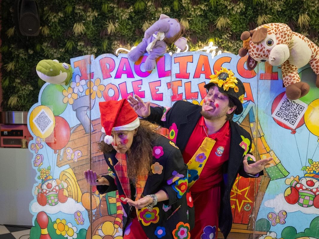 Due pagliacci si esibiscono davanti ai bambini sulla pedana luminosa
