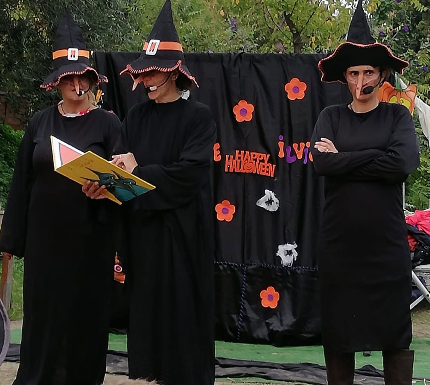 Tre streghe in scena durante una lettura animata di Halloween